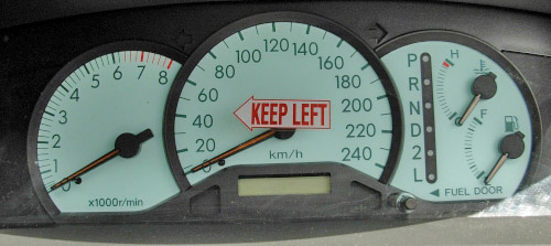 KEEP LEFT decal on rental car speedometer, which is good advice. This does pose one question. When deployed to McMurdo, operated by USA, and driving to the near by Scott Base, operated by New Zealand, do we change to the other side of the road?