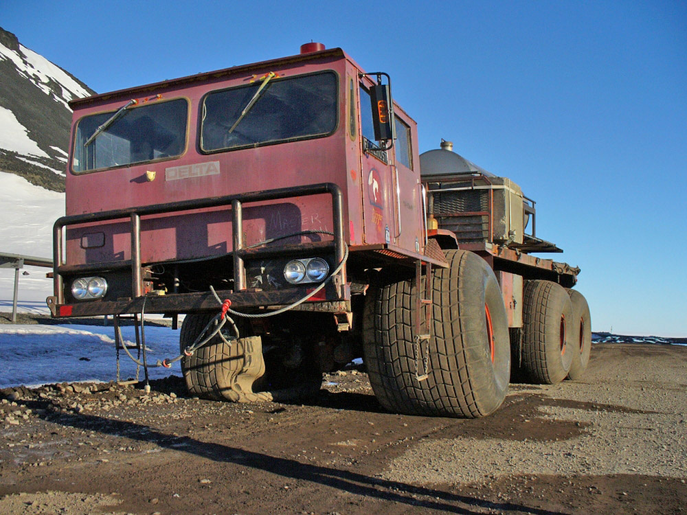 A six-pack of fat tires on a mongo truck with one flat tire.