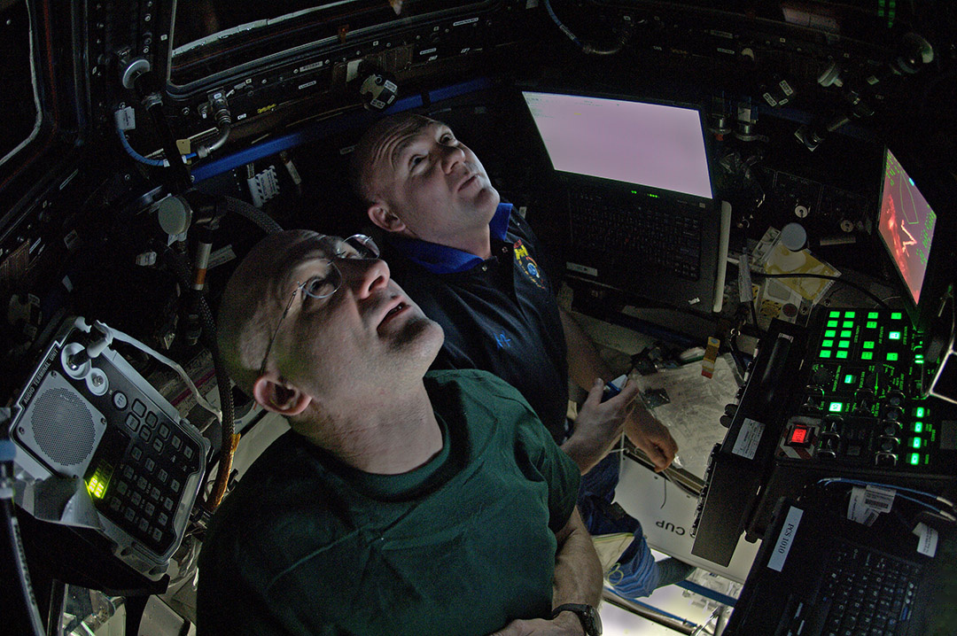 Capture the dragon; Gardner and crew operate the robotic arm from the room of windows.  This dragon came at night.